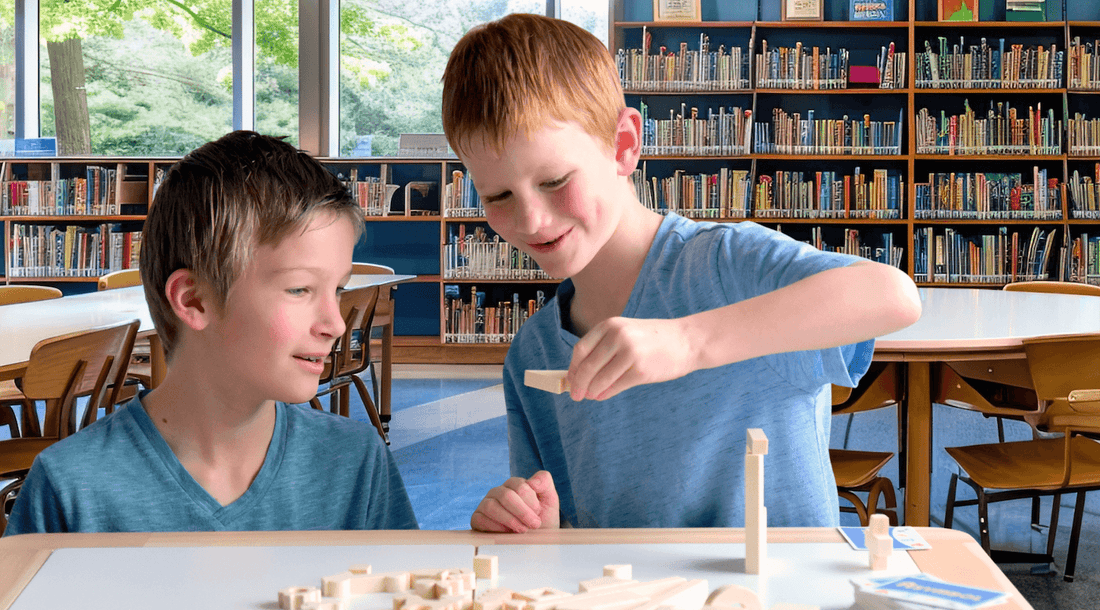 Boys playing creativity and communication game, Asymbol in school library