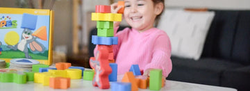 Child in pink shirt playing SimplyFun's My Fun Shapes
