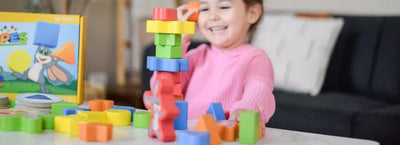 Child in pink shirt playing SimplyFun's My Fun Shapes