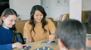 mom and family playing a board game called Marble Matrix.