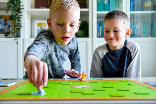 Blog header for teamwork for kids featuring two children playing Team Digger a teamwork game.