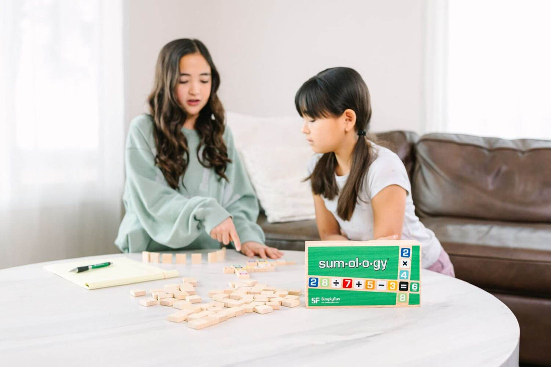 Two girls playing multiplication board game Sumology