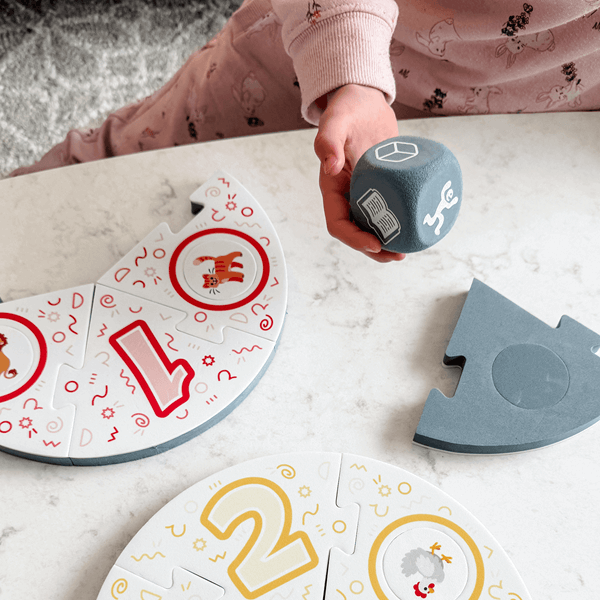 Dance Like a Lemur game from SimplyFun. Featuring a colorful box with playful lemur illustration and foam game puzzle pieces and die with a variety of animal and icon imagery. -SimplyFun