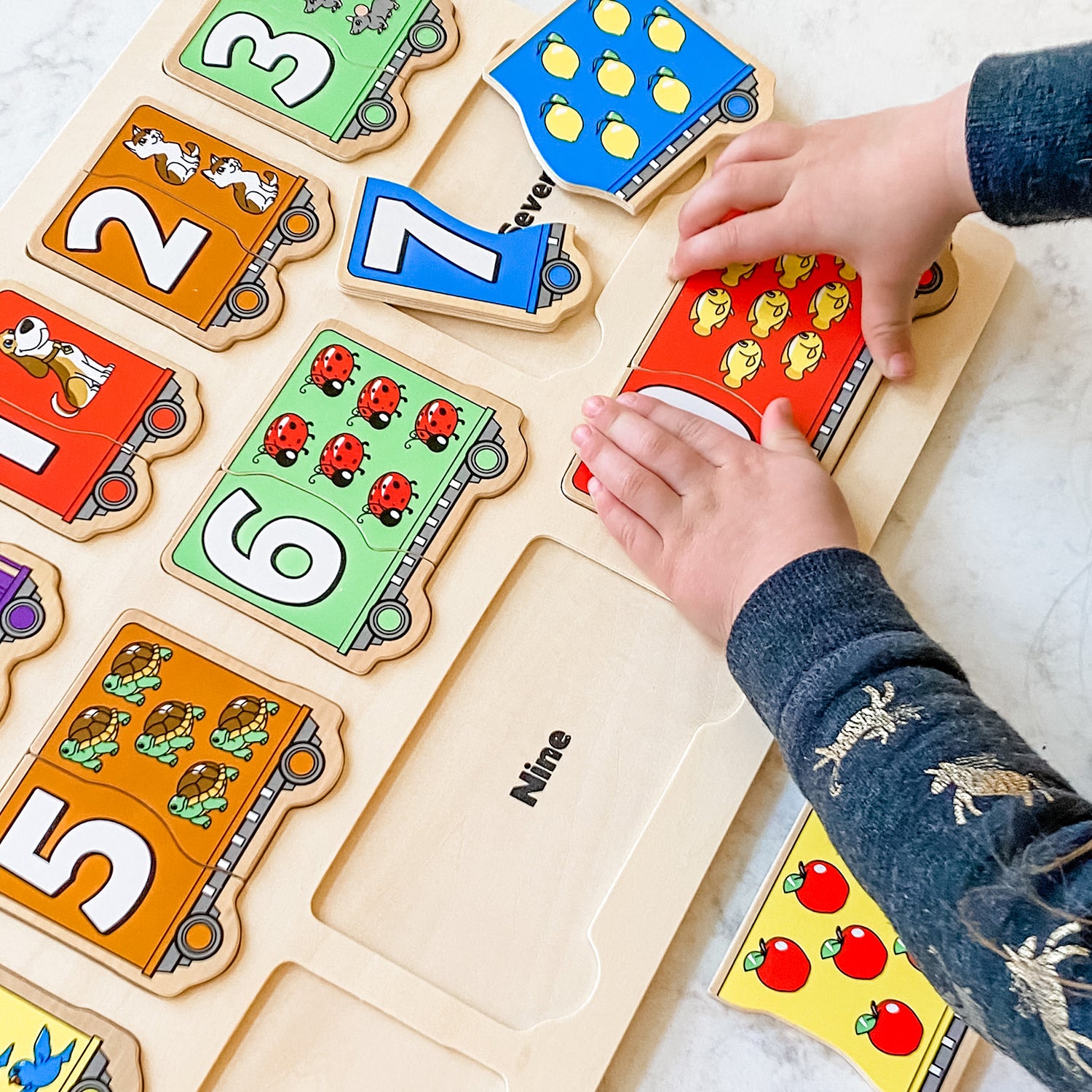 Tibbar's Little Hands, Big Smiles by SimplyFun is a set of three puzzles focusing on shapes, colors, lowercase and uppercase letters, and counting.