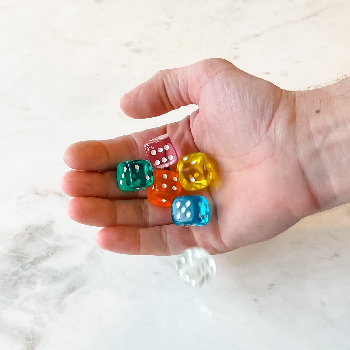 Six colorful dice in a travel box, with a dice game, by SimplyFun.